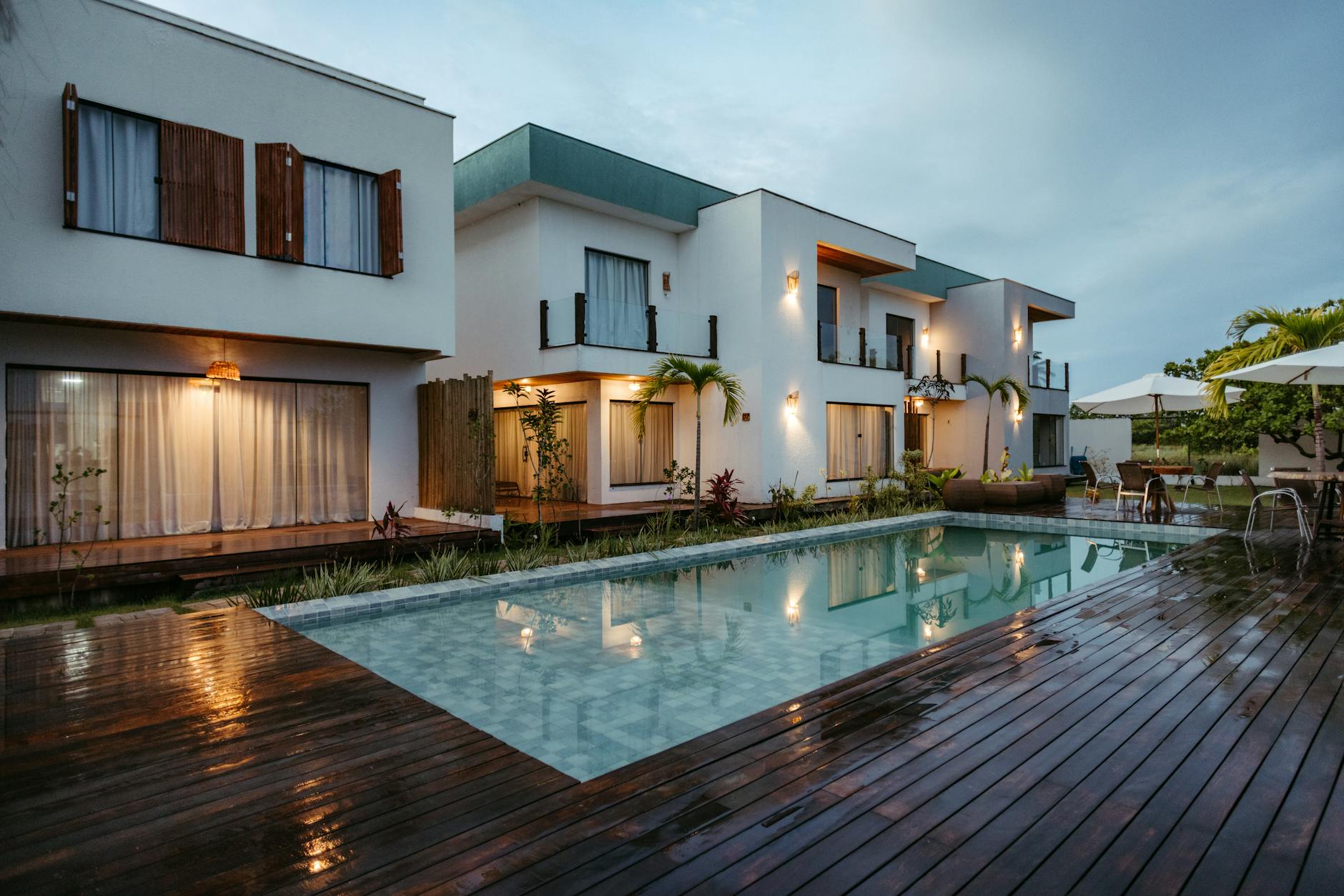 Luxury modern South Florida home exterior at dusk with pool
